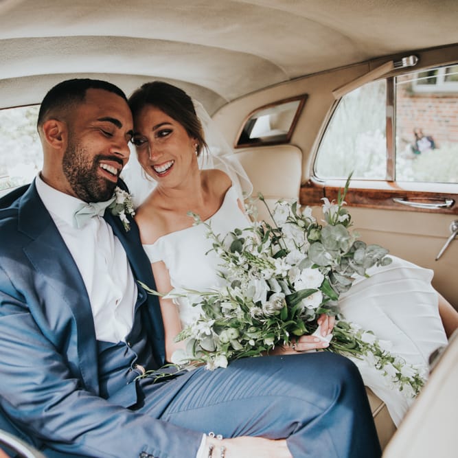 Bride and groom in white wedding car make their way to Bury Court Barn