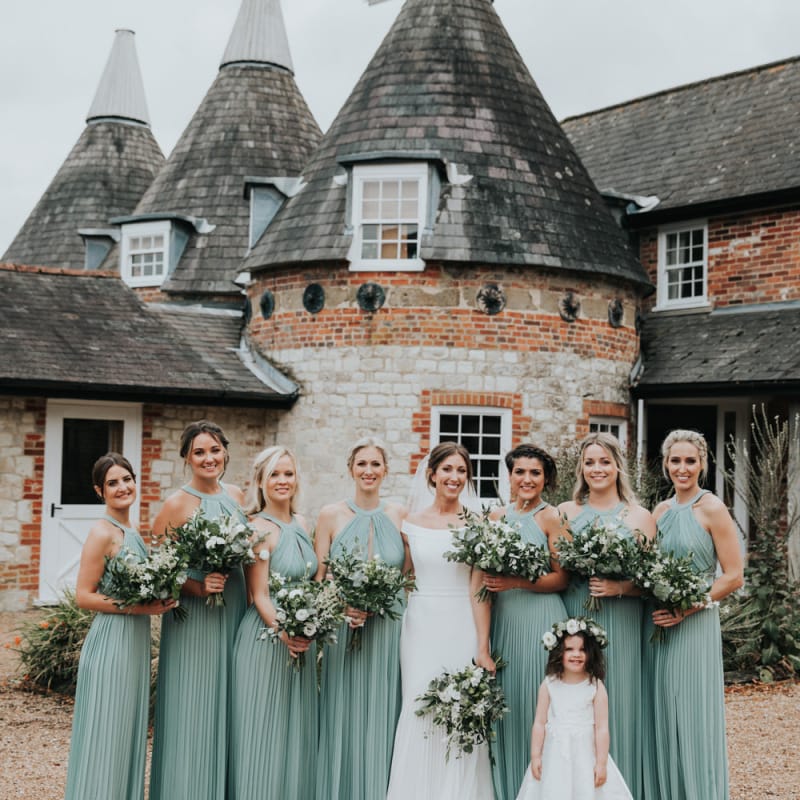 Bridesmaids in sage green dresses at Bury Court Barn