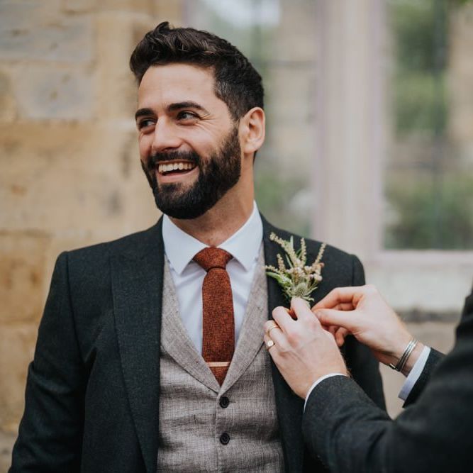 Groom wearing three piece suit and floral buttonhole at Newburgh Priory