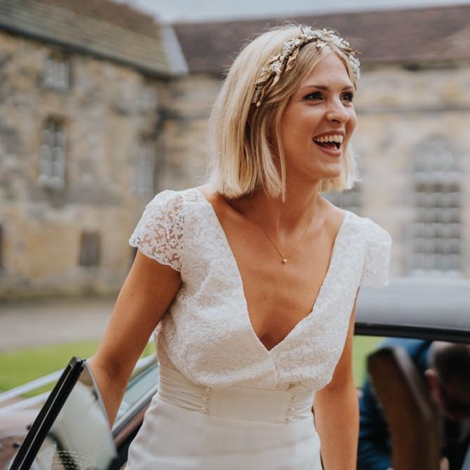 Bride arriving in a white vintage car at country house wedding with outdoor ceremony