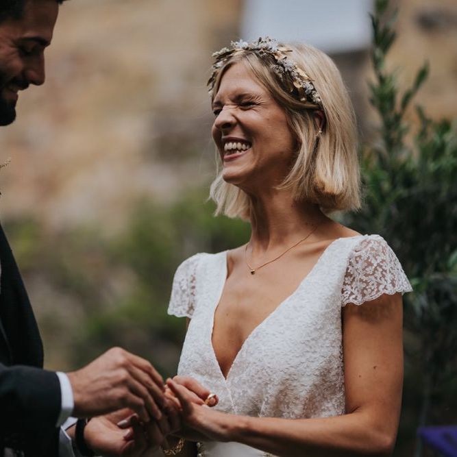 Bride wearing lace cap sleeved dress and gold embellished headband