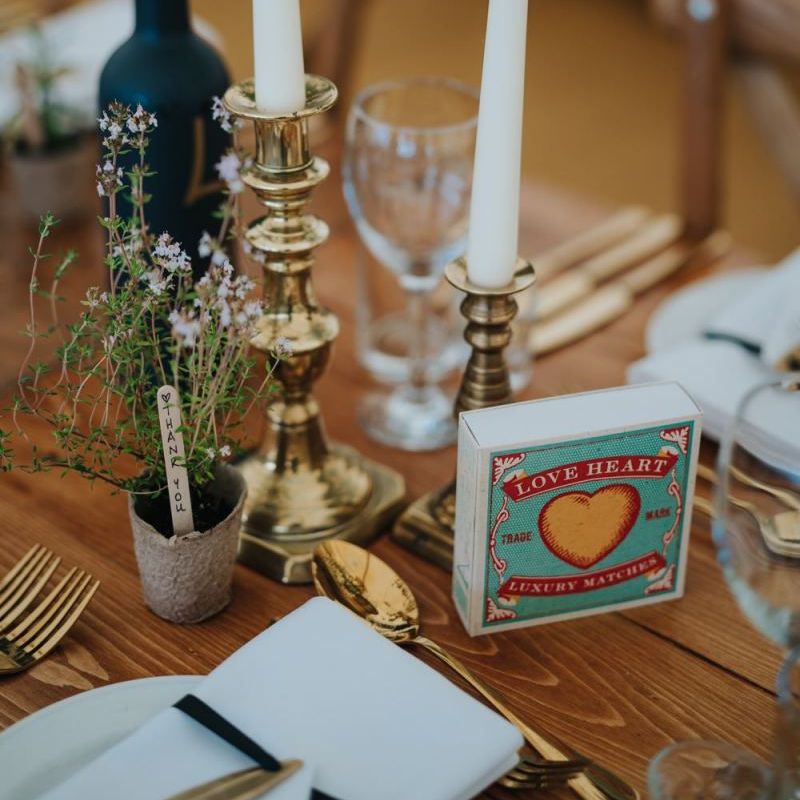 Gold candlesticks with white taper candles at marquee reception