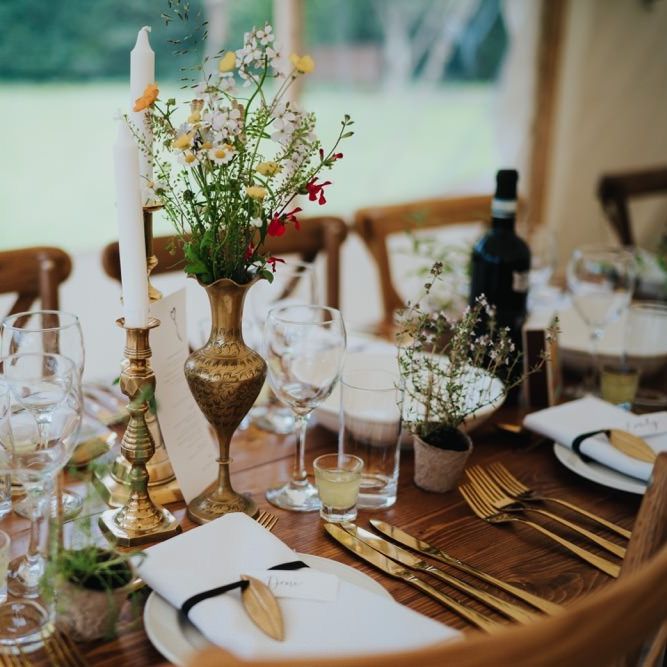 Gold candlesticks and foliage decor at marquee reception