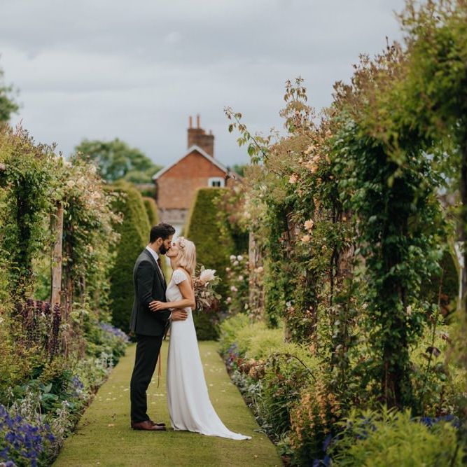 Bride and groom embrace in the gardens at Newburgh Priory for outdoor wedding