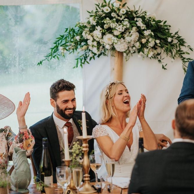 Bride and groom celebrate at their reception with white floral decor