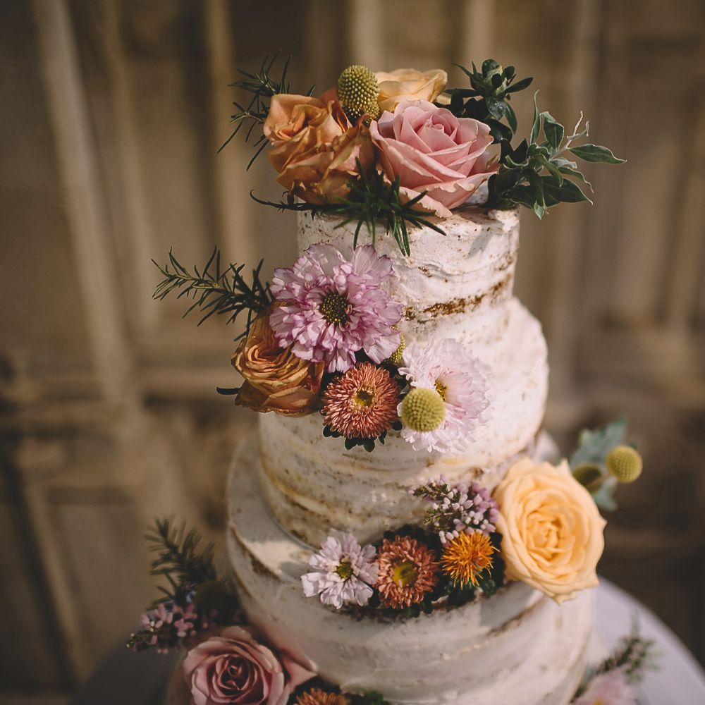 Semi Naked Wedding Cake with Pink, Yellow an Peach Wedding Flowers