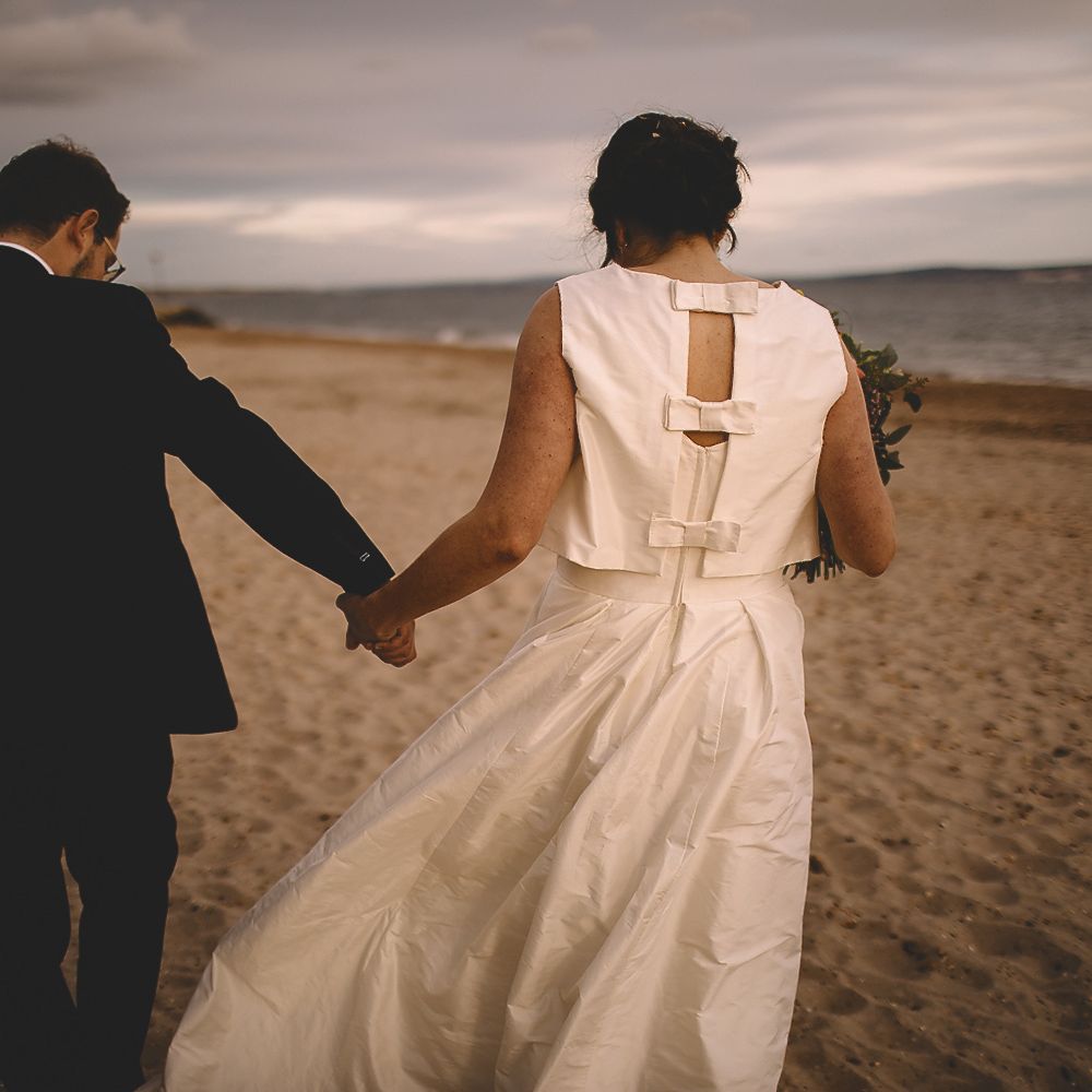 Bride in Homemade Wedding Dress with Bow Back and Groom in Dress2Kill Suit on the Beach