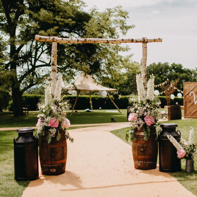 Welcome Entrance with Milk Churns, Barrels, &amp; Wooden Arch &amp; Sign | DIY Rustic Tipi Wedding at Riverhill Gardens, Sevenoaks | Frances Sales Photography