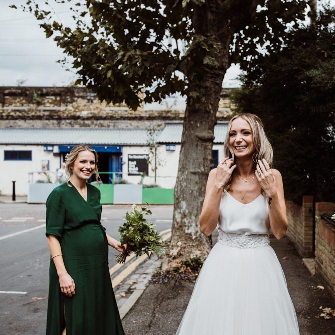 Bride wearing two piece Halfpenny London dress and her bridesmaids wearing emerald green dresses at Stoke Newington Town Hall