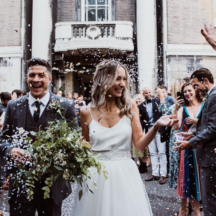 Confetti shot as couple exit Stoke Newington Town Hall with foliage bouquet