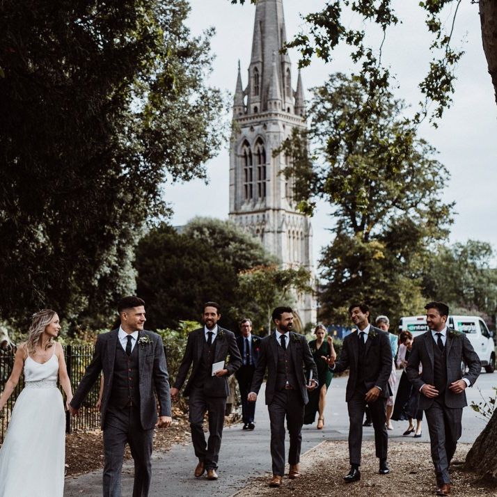Bride and groom walk with their guests to their reception