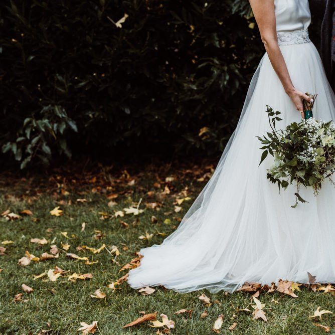 Brides wearing Halfpenny London dress with beautiful foliage bouquet