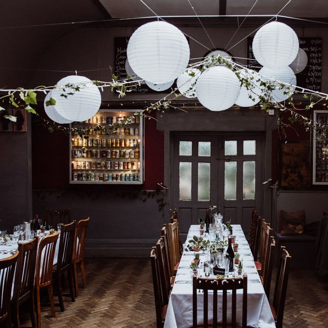 Reception styling with hanging foliage and white paper lantern decor