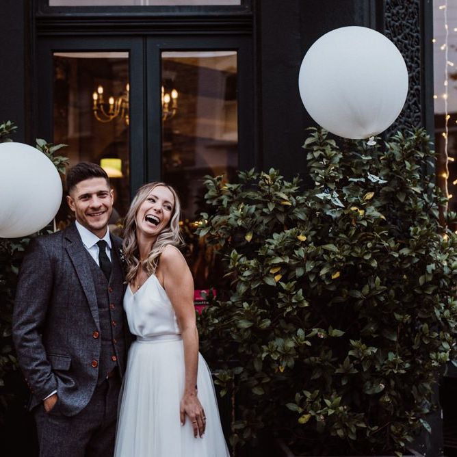 Bride and groom at pub reception with white paper lantern decor