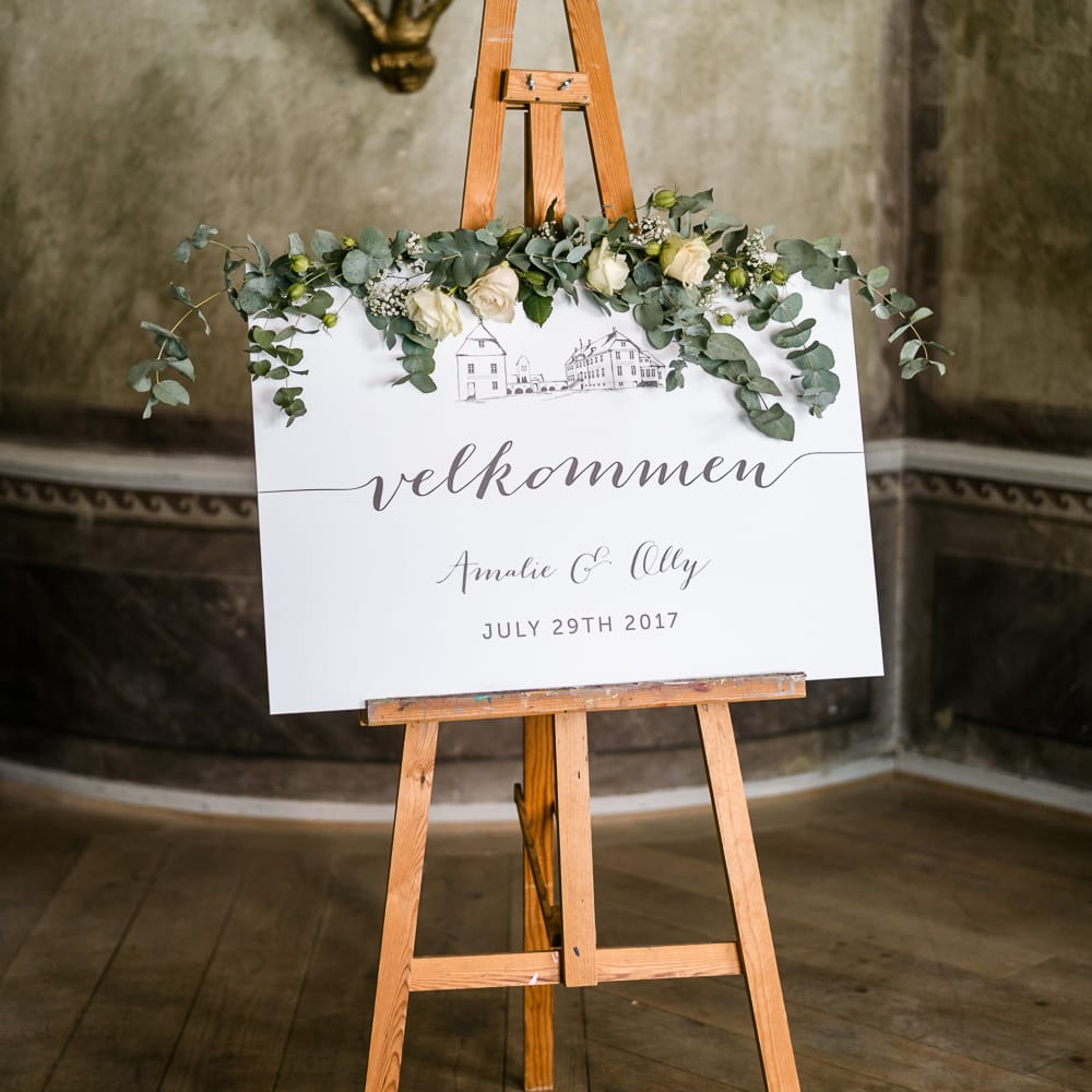 Welcome Sign on Easel | Traditional Green/Blue Danish Wedding at Scandinavian Country House, Jomfruens Egede in Faxe, Denmark | John Barwood Photography