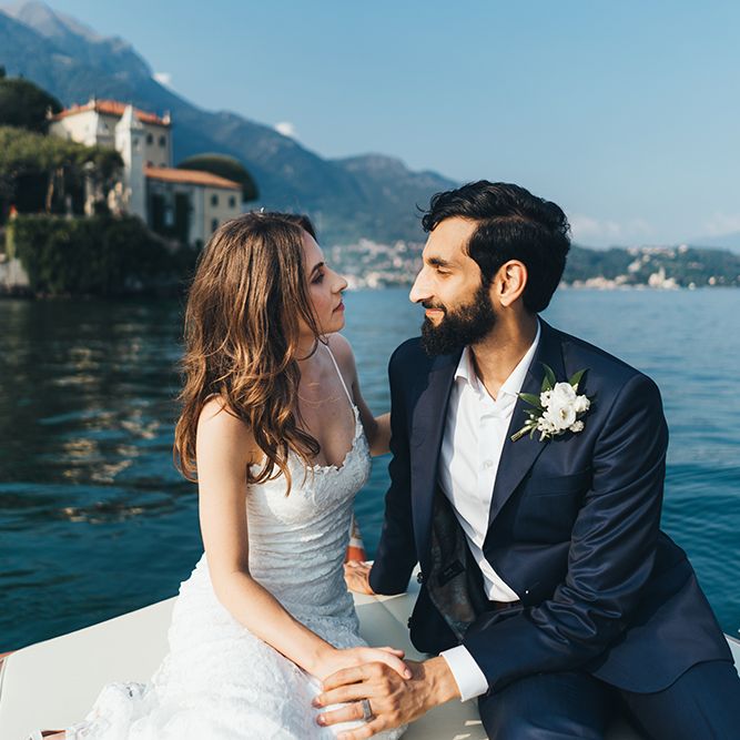 Bride in Grace Loves Lace Mia Wedding Dress and Groom in Taliare Navy Suit Enjoying a Boat Ride Over Lake Como