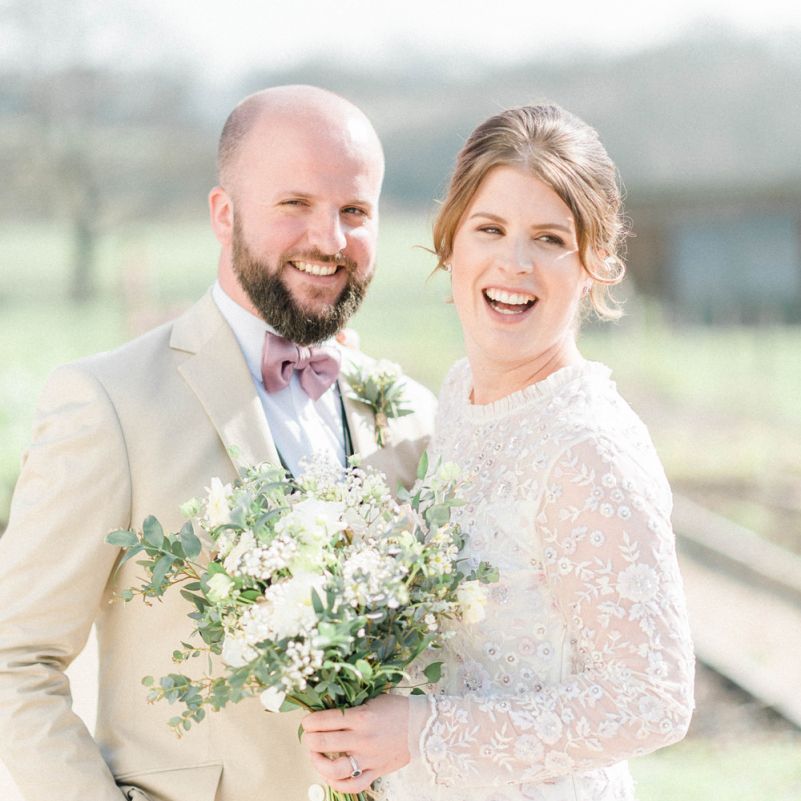 Bride in High Neck Needle &amp; Thread Wedding Dress and Bearded Groom in Bow Tie Laughing