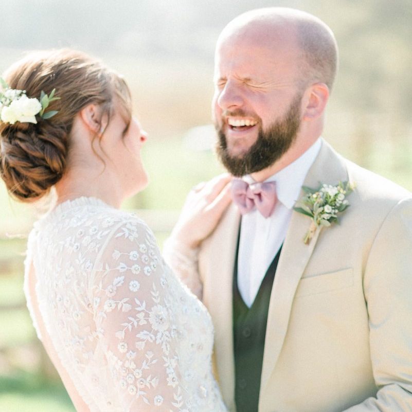 Bride in Needle &amp; Thread Wedding Dress and Groom in Beige Blazer and Pink Bow Tie Laughing Together