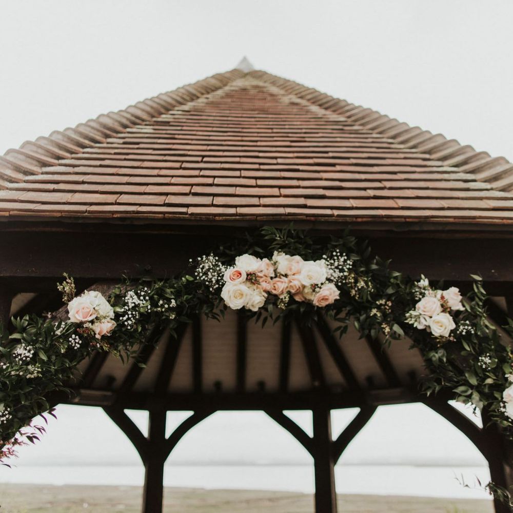 Pink rose floral archway for outdoor rustic ceremony at The Ferry House Inn