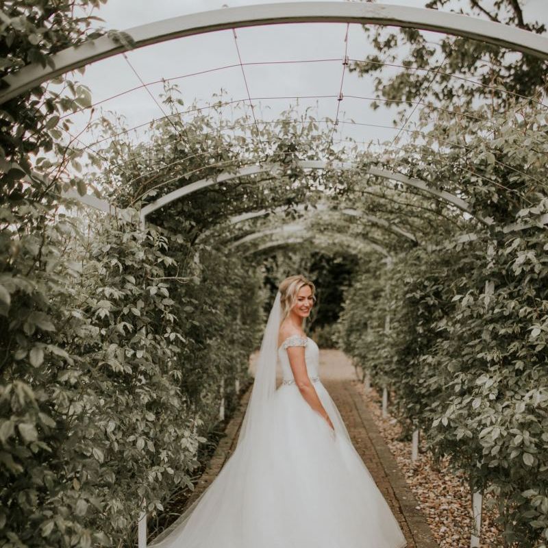 Bride wearing off the shoulder dress with embellished belt and veil at The Ferry House Inn
