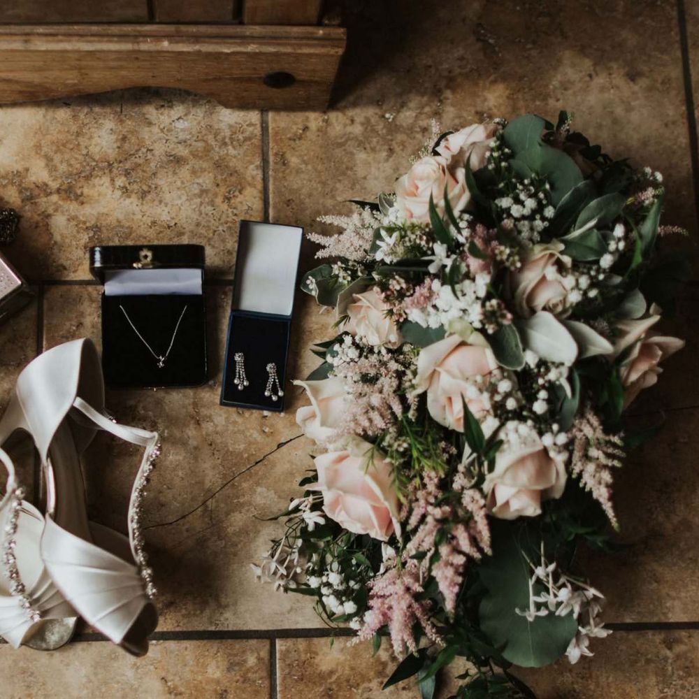 Bridal shoes and pink rose bouquet for rustic outdoor wedding in the summer