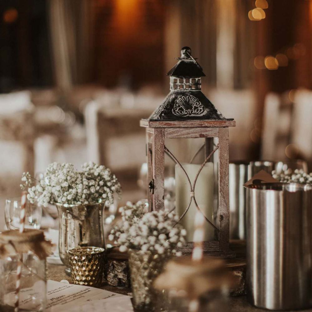 White floral decor with candle lanterns for rustic reception at The Ferry House Inn