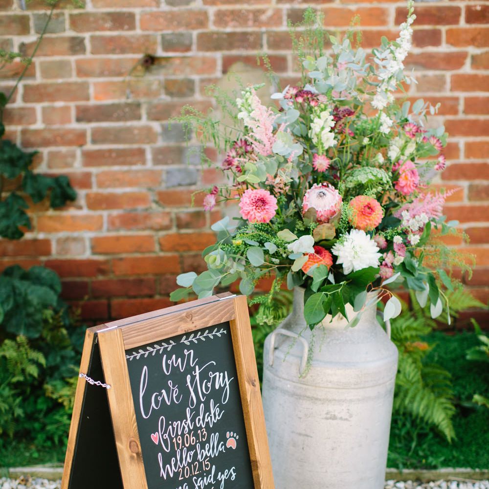 Milk Churn with Flowers and Black Board Wedding Sign | DIY Country Wedding at Warborne Farm, Lymington | Camilla Arnhold Photography