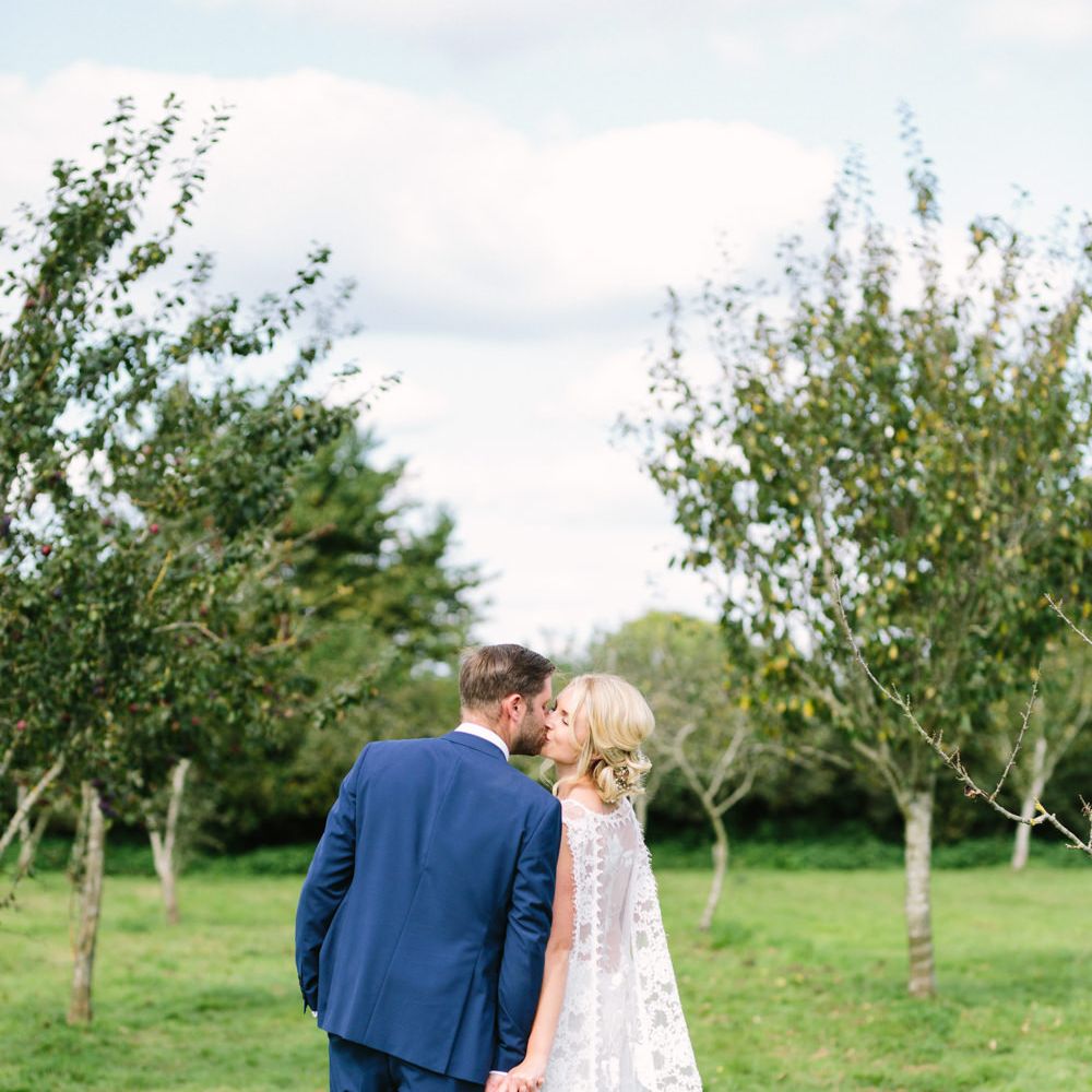 Bride in Claire Pettibone Whitney Bridal Gown with Cape | Groom in French Connection Navy Suit | DIY Country Wedding at Warborne Farm, Lymington | Camilla Arnhold Photography