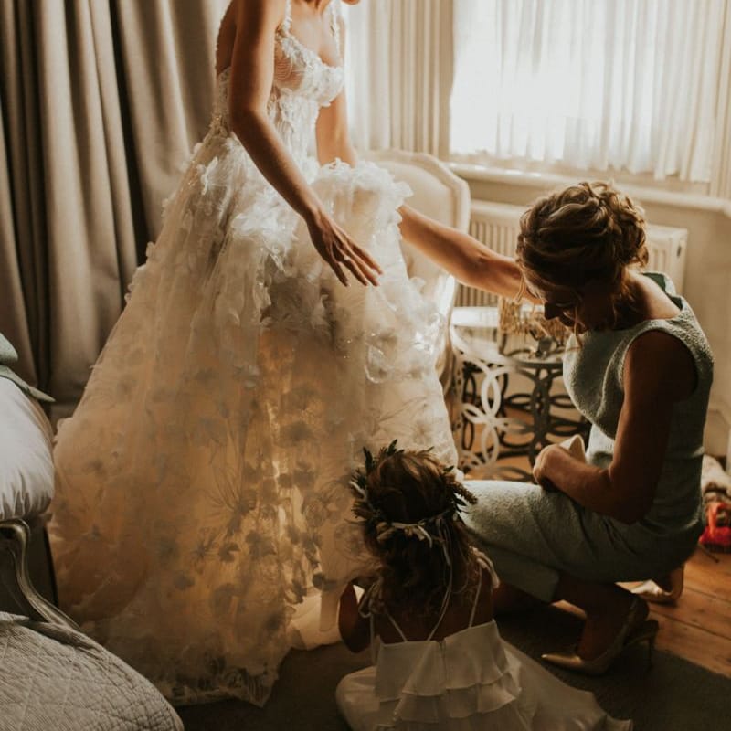Bride in Galia Lahav wedding dress putting on her wedding shoes