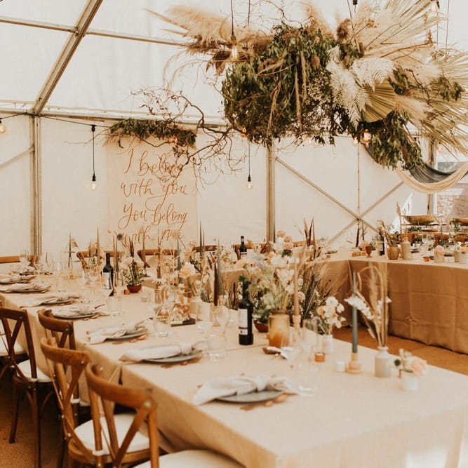 August 2020 wedding reception in a marquee with boho wedding flowers and decor