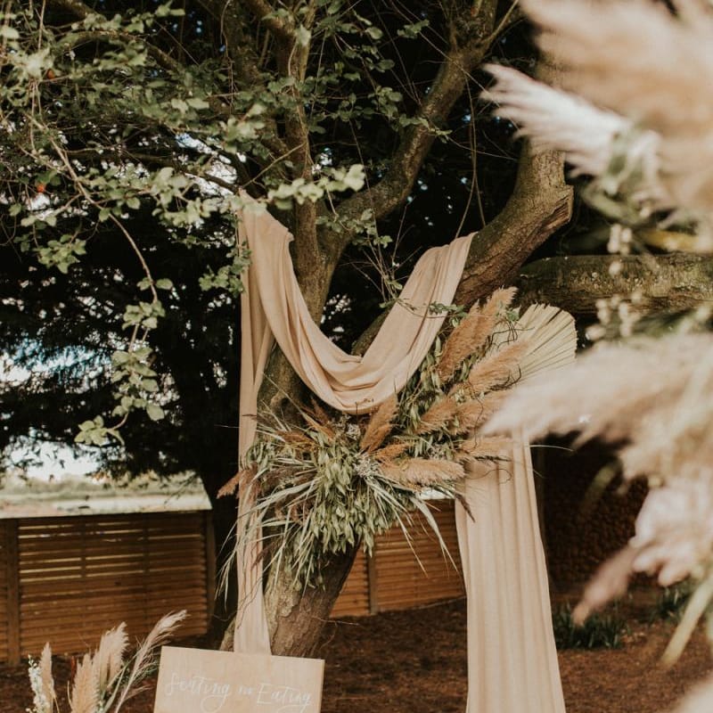 Boho decor and wooden seating chart for August 2020 wedding