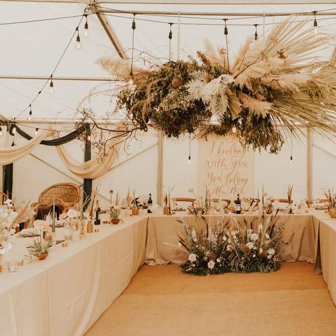 Festoon lights and hanging flower installations with pampas grass for August 2020 wedding reception