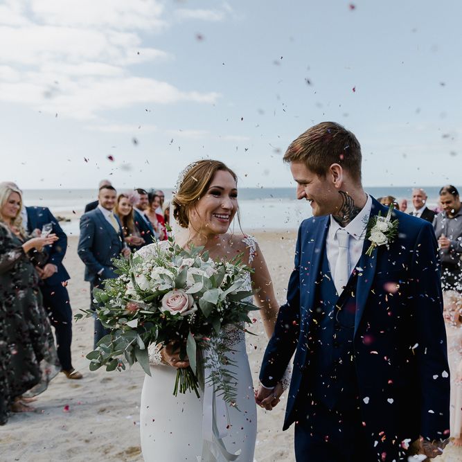 Beach Confetti Moment  | Bride in Lace Long Sleeve Martina Liana Wedding Dress | Groom in Navy Three-piece Suit | Lusty Glaze Beach Wedding Newquay Cornwall | Alexa Poppe PhotographyLusty Glaze Beach Wedding Newquay Cornwall | Alexa Poppe Photography