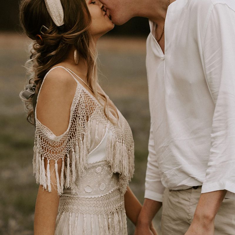 Boho Couple Kissing with Bride in Cold Shoulder Lace Dress and Groom in Fedora Hat