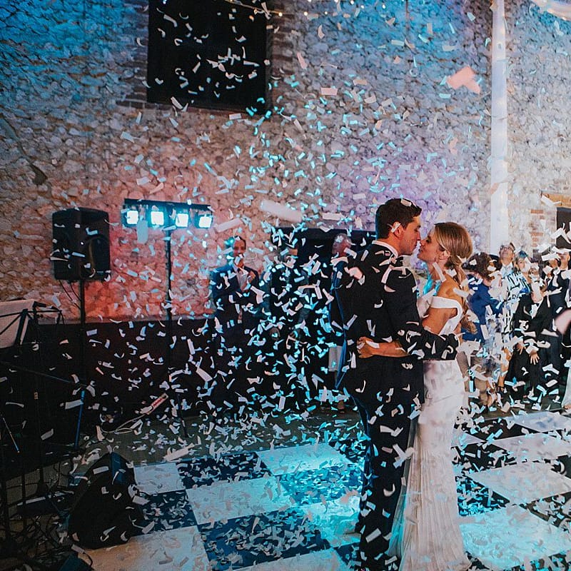 Confetti Cannon First Dance | Bride in Suzanne Neville Bardot Nouveau Wedding Dress | Groom in Black Tie | Pastel Pink &amp; Mint Green Wedding at Granary Estates Suffolk | Julia &amp; You Photography
