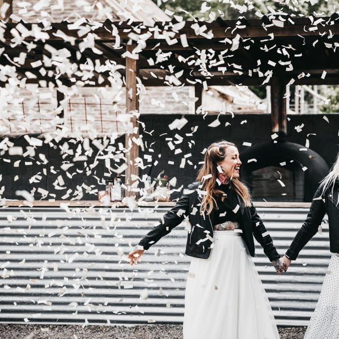 Confetti cannon moment with brides in black and white dress and separates