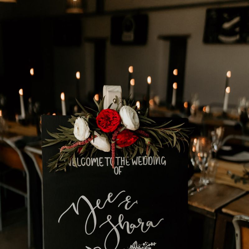Black Wedding Welcome Sign with White Font and Red &amp; White Floral Decor
