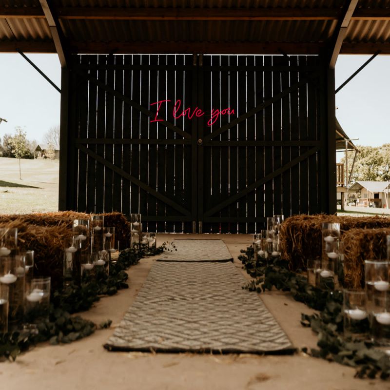 Barn Wedding Ceremony with Hay Bales and Pink Neon I Love You Sign