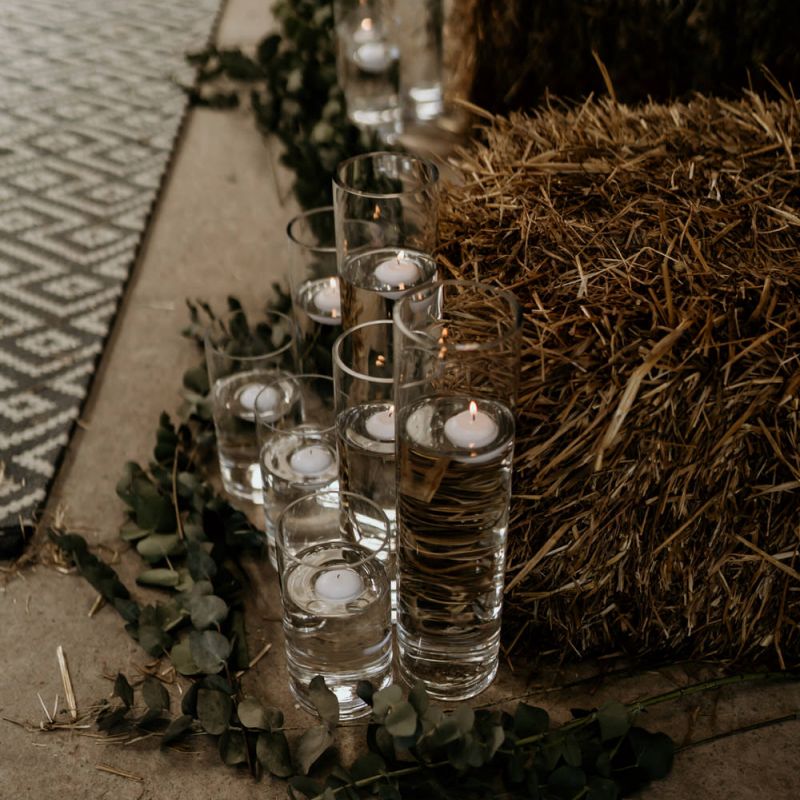 Floating Candles in Tall Vases Lining the Aisle