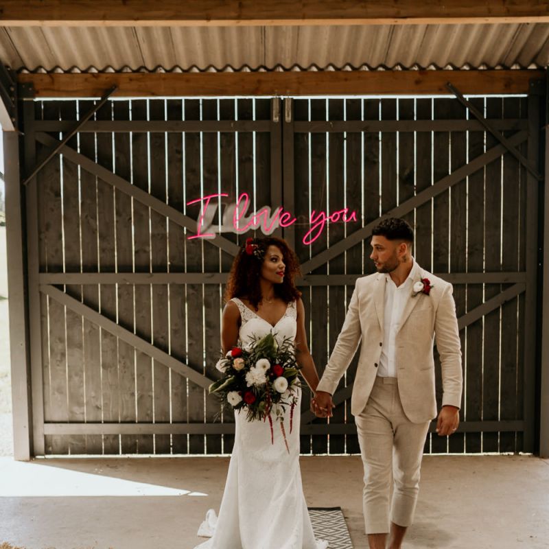 Black Bride with Afro Hair in a Lace Wedding Dress and Groom in Blazer Walking up The Aisle Lined with Rugs