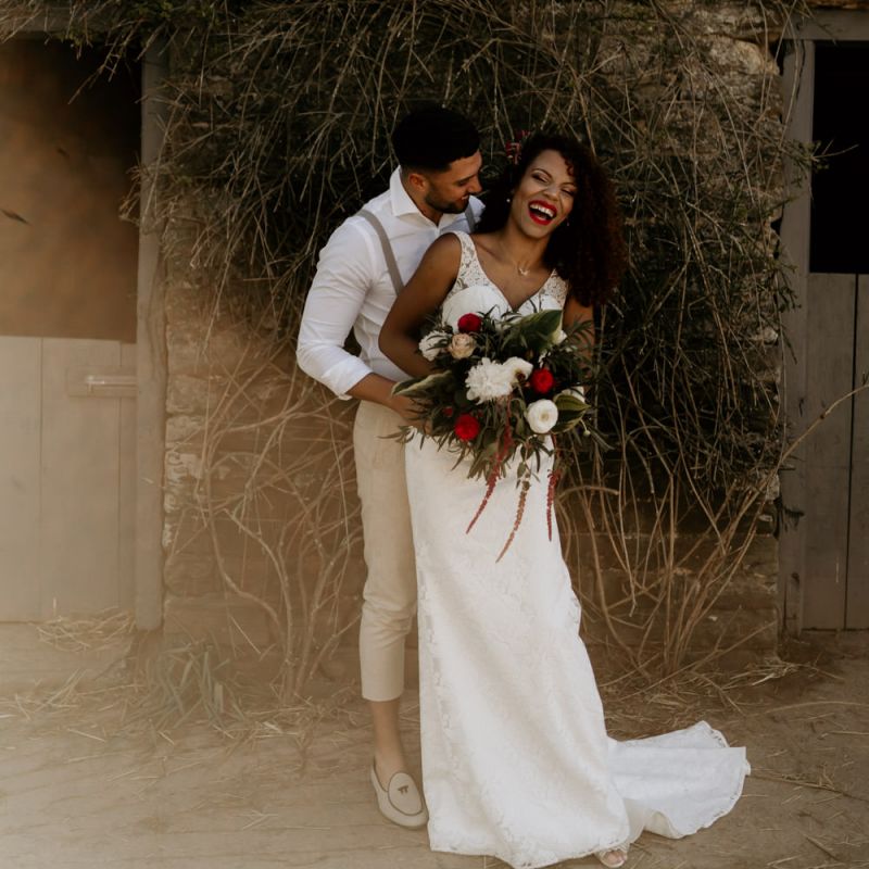 Black Bride with Afro Hair in a Lace Wedding Dress and Groom in White Shirt and Braces Laughing