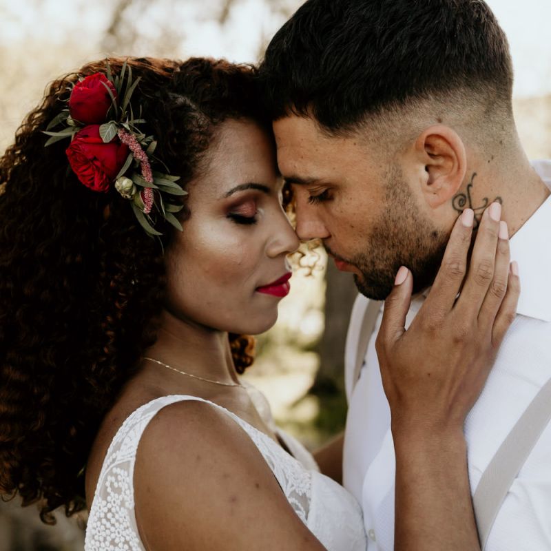 Black Bride with Afro Hair and Fresh Fresh Flowers in a Lace Wedding Dress Being intimate with her Groom