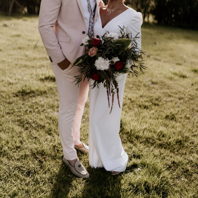 Black Bride in White Jumpsuit with Head Wrap  and Groom in Pink Suit