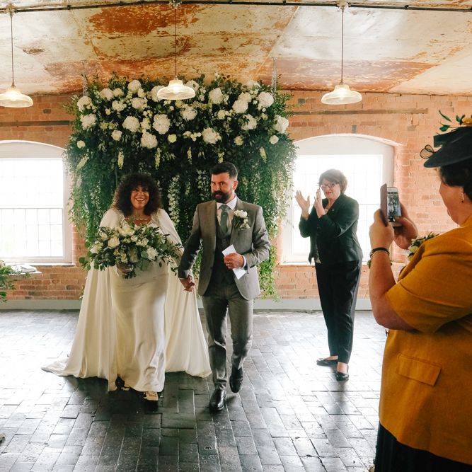 Stylish black bride in wedding cape for industrial wedding at West Derby Mill