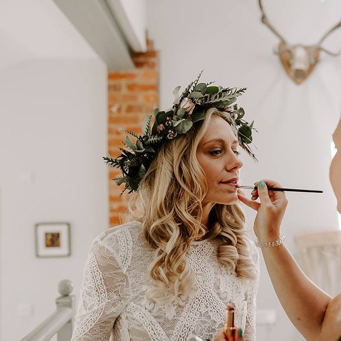 Finishing touches for bride wearing flower crown
