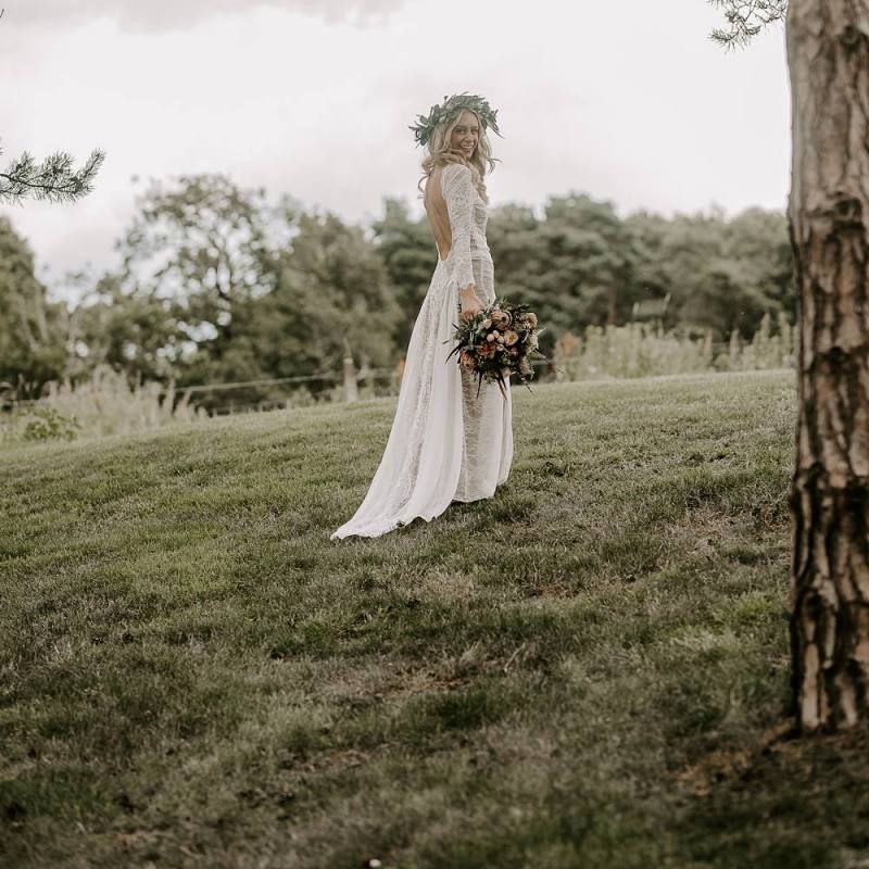 Bride in low back wedding dress with flower crown and Protea bouquet