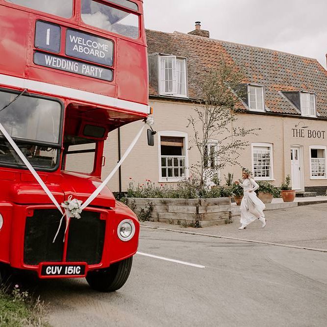 Bride makes her way onto red bus wedding transport