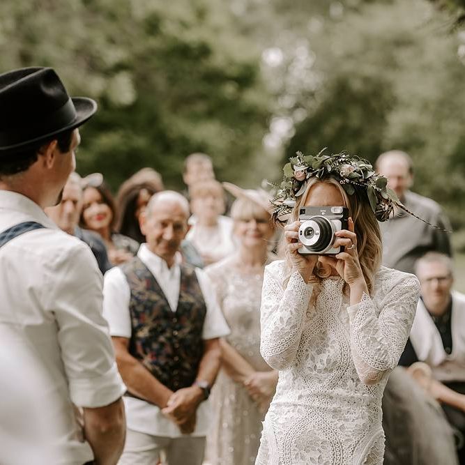 Bride takes a photo of her groom at the altar