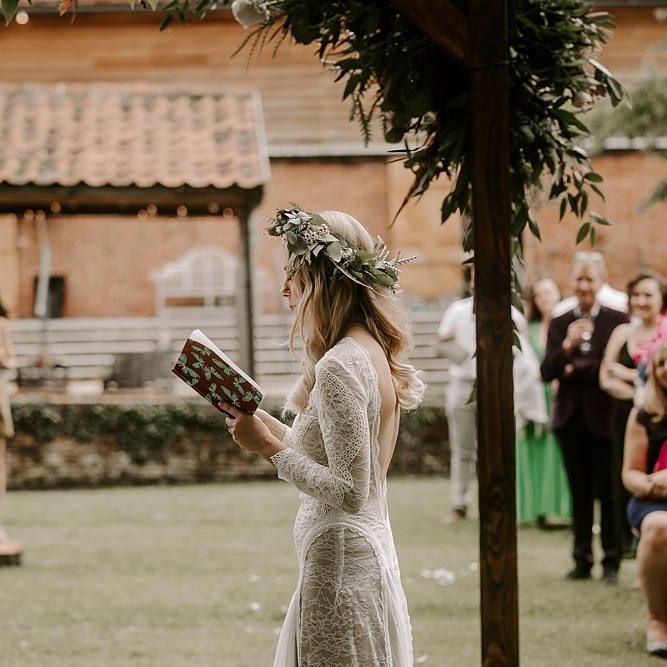 Bride reading her wedding vows during outdoor ceremony