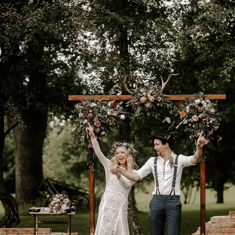 Bride clutching Protea bouquet with new husband celebrating